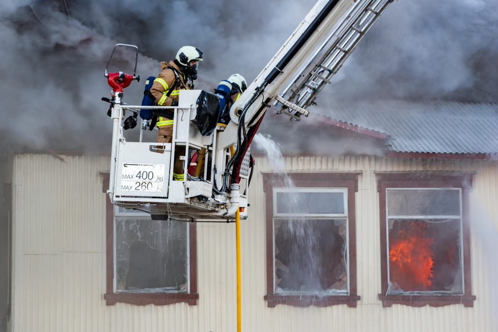 Fire professionals extinguishing a house fire.